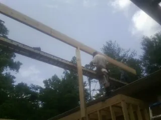 Carpenter setting a ridge beam over a new addition frame — Ice Dam Removal by Roofing Brothers in Crystal City