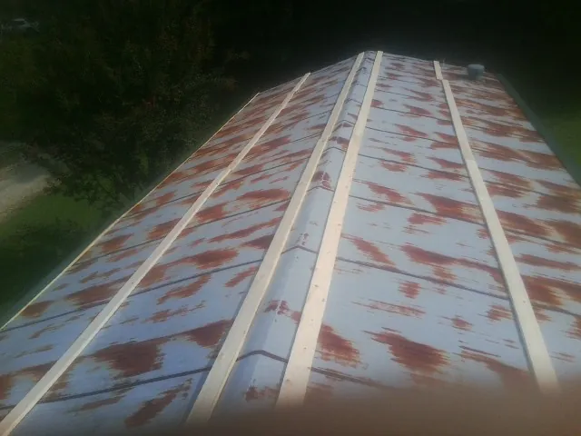 Rusted metal roof panels with new wood purlins before replacement — Storm Damage Roof Repair in Crystal City by Roofing Brothers